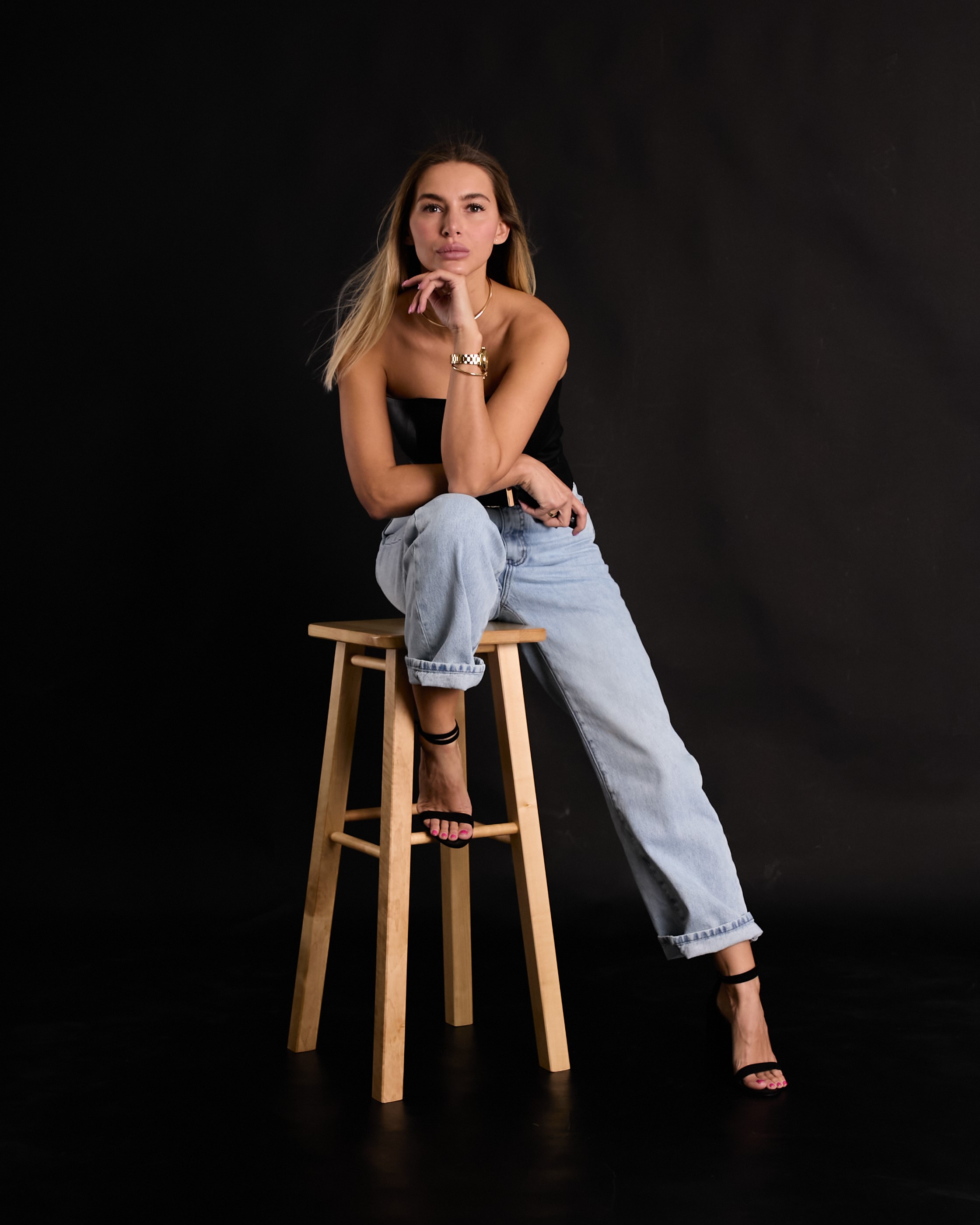 Девушка на стуле на черном фоне